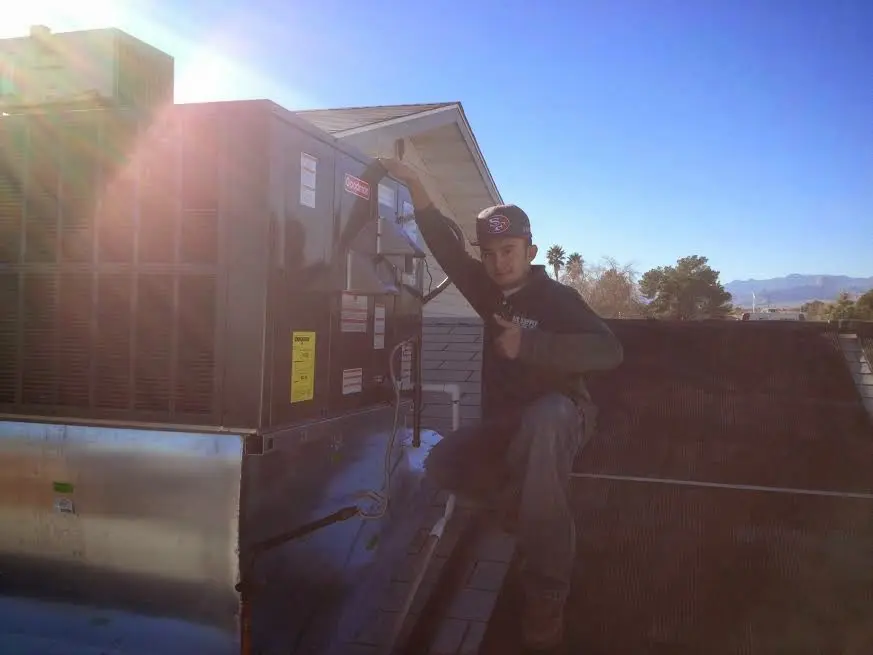 HVAC technician performing HVAC Inspection on a rooftop unit in Auburn
